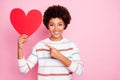 Photo of pretty dark curly skin lady holding in hands big red paper heart advising to choose creative present wear