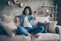 Photo of pretty dark skin wavy lady homey mood holding tv remote control changing channel searching favorite humor show Royalty Free Stock Photo