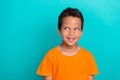 Photo of pretty dreamy small man wear yellow t-shirt smiling looking empty space turquoise color background