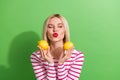 Photo of pretty flirty young girl wear striped top kisses you hold two lime citrus fruits pouty lips isolated on green Royalty Free Stock Photo