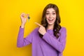 Photo of pretty impressed lady wear violet sweater pointing finger house keys isolated yellow color background