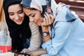 Photo of pretty islamic girls wearing headscarfs sitting in green park