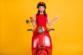 Photo of pretty lady wear red dress headwear sitting bike holding modern gadget pointing empty space isolated yellow Royalty Free Stock Photo