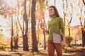 Photo of pretty lovely lady walk hold laptop drink coffee smiling see friend another corner autumn park heading towards