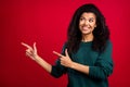 Photo of pretty nice afro american young woman look point finger empty space isolated on red color background