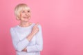 Photo of pretty retired woman look indicate finger empty space promotion follow advertising isolated over pink color