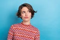 Photo of pretty serious lady looking side empty space suspicious person wear print shirt isolated blue color background