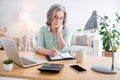 Photo of pretty serious woman arm hole pen take notes notepad sit behind desk working from home indoors Royalty Free Stock Photo