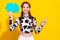 Photo of pretty shiny woman wear cow skin print top rising talking cloud pointing empty space isolated yellow color Royalty Free Stock Photo