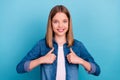 Photo of pretty teenager blond girl thumb up wear jeans shirt isolated on blue color background Royalty Free Stock Photo