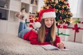 Photo of pretty teenager lying fluffy carpet home write letter saint nicholas want dream come true enjoy magic time room