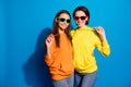 Photo of pretty two girlfriends lady standing hugging ready for holidays and rest wear sun specs casual bright hoodies Royalty Free Stock Photo