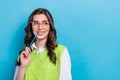 Photo of pretty young girl eyeglasses pencil touch mouth look empty space dressed stylish green look isolated on blue Royalty Free Stock Photo