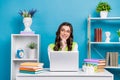 Photo of pretty young girl eyeglasses workstation look empty space dressed stylish green outfit isolated on blue color Royalty Free Stock Photo