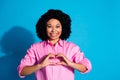 Photo of pretty young woman arms show heart symbol wear pink shirt isolated on blue color background Royalty Free Stock Photo