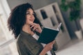 Photo of pretty young woman hold book fantasize wear khaki shirt modern interior house indoors