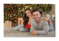 Photo printed on canvas, white background. Happy young couple lying on floor in living room decorated for Christmas Royalty Free Stock Photo