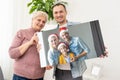 Photo printed on canvas, white background. Happy young family in Santa hats celebrating Christmas at home Royalty Free Stock Photo