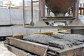 Photo of the production of reinforced concrete lintels, pouring the preheated metal mold with concrete. Royalty Free Stock Photo