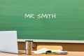 Photo of professor desk in classroom with Mr Smith name written in black board