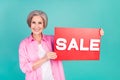 Photo of promoter elderly woman dressed pink trendy shirt promoting sale in local store with ad placard isolated on blue