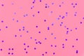 Photo of purple hearts glitter sprinkles on pink trendy background. Festive holiday background for your projects. Celebration