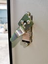 Photo of push lock without key red button mount on electrical cabinet door. Royalty Free Stock Photo