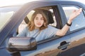 Photo of puzzled woman gestures though car window, being annoyed to wait for long and stand in traffic jam, hurries for important