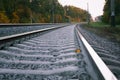 Photo of the railway. Steel rails, concrete sleepers, gravel filling. Autumn urban landscape. Railway landscape