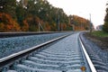 Photo of the railway. Steel rails, concrete sleepers, gravel filling. Autumn urban landscape. Railway landscape