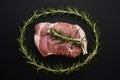 Photo Raw lamb adorned with rosemary, striking contrast on black backdrop