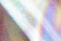 Photo of a real light rainbow crumpled holographic background with a skin texture with rays daylight