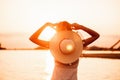 Photo a rear view of a young woman with a hat. A beautiful happy blonde in a lace summer dress and a straw hat decorated Royalty Free Stock Photo