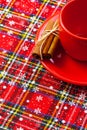 Photo of red cup of coffee, cinnamon and placemats