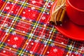 Photo of red cup of coffee, cinnamon and placemats