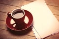 photo of red cup of coffee and several envelopes on the wonderful brown wooden background