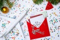 Photo of red envelope, cookies, plane, branches of spruce Christmas decorations.