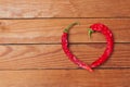 Photo of red heart shape chili pepper on wooden background