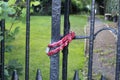 Red lock tied around black entrance gate