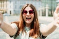 Photo relaxed charming positive young woman hold camera and make selfie summer outside in city center outdoors