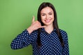 Photo of responsible girl ask call back fingers phone gesture wear dotted blouse isolated on green color background