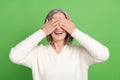 Photo of retired funny grey hair lady cover eyes closed laughing joking carefree peekaboo playing isolated on green Royalty Free Stock Photo