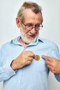 Photo of retired old man in blue shirts bitcoin in hands light background Royalty Free Stock Photo