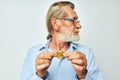 Photo of retired old man in blue shirts bitcoin in hands light background Royalty Free Stock Photo