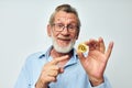 Photo of retired old man in blue shirts bitcoin in hands light background Royalty Free Stock Photo