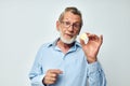 Photo of retired old man in blue shirts bitcoin in hands light background Royalty Free Stock Photo