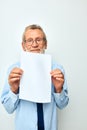 Photo of retired old man holding documents with a sheet of paper light background Royalty Free Stock Photo