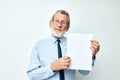 Photo of retired old man holding documents with a sheet of paper light background Royalty Free Stock Photo