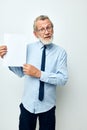 Photo of retired old man holding documents with a sheet of paper light background Royalty Free Stock Photo