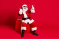 Photo of retired old man white beard sit giftbox show v-sign make selfie portrait stick-out tongue wear x-mas santa Royalty Free Stock Photo